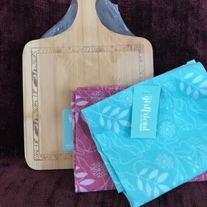 Small bamboo cutting board and two kitchen towels.